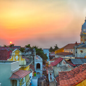 View over the rooftops of the old city of Cartagena during a vibrant sunset. The spire of Cartagena Cathedral stands tall and proud.